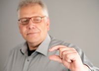 Körpersprache und Nonverbale Kommunikation. Beispiel für eine einfache Fingergeste, Daumen, Zeigefinger: so klein